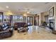 Bright living room features tile floors, fireplace, ceiling fan, and leather furniture at 5445 Pendini Point Ct, Las Vegas, NV 89141