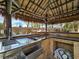 Outdoor kitchen boasts stainless steel sink and storage under a thatched roof pergola at 5445 Pendini Point Ct, Las Vegas, NV 89141
