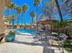 Backyard with a sparkling pool, tiki bar, rock features, and lounge area at 5445 Pendini Point Ct, Las Vegas, NV 89141
