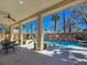 Covered patio area features a dining set and a beautiful pool with a rock waterfall feature at 5445 Pendini Point Ct, Las Vegas, NV 89141