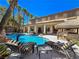 Spacious backyard featuring a sparkling pool, rock waterfall, tiki huts, and a lounge area for relaxation at 5445 Pendini Point Ct, Las Vegas, NV 89141