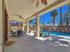 Relaxing covered patio with outdoor dining area overlooks a stunning pool with rock waterfall feature at 5445 Pendini Point Ct, Las Vegas, NV 89141