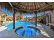 Inviting backyard pool and hot tub with tiki hut, waterfall, and ample seating for outdoor relaxation at 5445 Pendini Point Ct, Las Vegas, NV 89141
