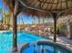 Relaxing backyard pool with a tiki hut, rock waterfall, and tropical landscaping offering a private oasis at 5445 Pendini Point Ct, Las Vegas, NV 89141