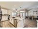 Bright kitchen features an island with stainless steel appliances and seating, opening into dining area at 5638 Wild Olive St, Las Vegas, NV 89118