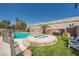 Backyard with a sparkling pool, a spa, rock waterfall, and artificial grass at 5638 Wild Olive St, Las Vegas, NV 89118