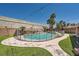 Sparkling pool surrounded by lush landscaping, a rock feature, and secure safety fencing at 5638 Wild Olive St, Las Vegas, NV 89118