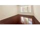 An empty bedroom offering wood flooring and natural light through a large window at 5710 E Tropicana Ave # 1055, Las Vegas, NV 89122
