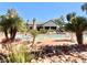 Community pool area landscaped with rocks, grass and palm trees at 5710 E Tropicana Ave # 1055, Las Vegas, NV 89122