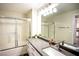 Modern bathroom featuring a granite countertop, a large mirror, and a shower with glass doors at 6160 Rumrill St # 121, Las Vegas, NV 89113