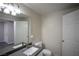 Compact bathroom with a white toilet, gray countertop, and bright vanity lighting at 6160 Rumrill St # 121, Las Vegas, NV 89113
