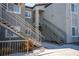 Modern condo with gray stucco, white trim, and staircase leading to upper units and walkways at 6160 Rumrill St # 121, Las Vegas, NV 89113