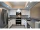 Modern kitchen with stainless steel appliances, white cabinetry, gray countertops, and ample lighting at 6160 Rumrill St # 121, Las Vegas, NV 89113