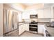 Well-equipped kitchen with stainless appliances, white cabinetry, and gray countertops; bright and modern at 6160 Rumrill St # 121, Las Vegas, NV 89113