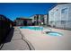 Community pool with hot tub in the foreground, featuring a clear blue sky at 6160 Rumrill St # 121, Las Vegas, NV 89113
