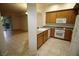 Well-lit kitchen with wooden cabinets, granite countertops, and tile flooring at 62 E Serene Ave # 129, Las Vegas, NV 89123