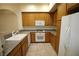 Cozy kitchen with wood cabinets, granite counters, and modern white appliances at 62 E Serene Ave # 129, Las Vegas, NV 89123
