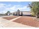 Charming single-story home featuring rock landscaping, a unique black and white exterior paint, and mature tree at 6205 Hargrove Ave, Las Vegas, NV 89107