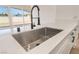 Close-up of a kitchen sink featuring modern fixtures, quartz countertops, and stainless steel sink basin at 6205 Hargrove Ave, Las Vegas, NV 89107