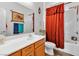 Bright bathroom featuring a single sink vanity, mirror, and shower with a patterned red curtain at 6829 Painted Morning Ave, Las Vegas, NV 89142