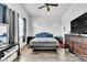Spacious bedroom featuring three bright windows, a ceiling fan, and wood-look floors at 6829 Painted Morning Ave, Las Vegas, NV 89142