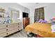 Comfortable bedroom with dresser, mirror, TV and bed with gold comforter, filled with personal items at 6829 Painted Morning Ave, Las Vegas, NV 89142