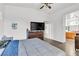 Bright bedroom featuring wood look floors and a large dresser with tv at 6829 Painted Morning Ave, Las Vegas, NV 89142