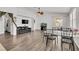 Open-concept living room with hardwood floors, ceiling fan, TV, and access to outdoor patio at 6829 Painted Morning Ave, Las Vegas, NV 89142