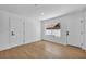 A bedroom with wood-look flooring, a window showing exterior view, and two white paneled doors at 6939 Paddington Way, Las Vegas, NV 89147