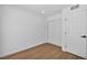 A minimalist bedroom featuring wood-look floors, a closet with sliding doors, and a white paneled door at 6939 Paddington Way, Las Vegas, NV 89147