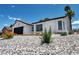 Single-story home with low-water landscaping featuring rocks, small plants, and desert accents at 6939 Paddington Way, Las Vegas, NV 89147
