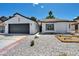 Inviting single-story home featuring low-water rock landscaping, desert plants, and a two-car garage at 6939 Paddington Way, Las Vegas, NV 89147
