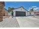 Single-story home with a low-water rock garden, desert landscaping, and two-car garage at 6939 Paddington Way, Las Vegas, NV 89147