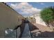 View of backyard pathway and rock landscaping, secured by a metal gate at 7697 Morning Lake Dr, Las Vegas, NV 89131