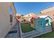 Fenced backyard featuring artificial grass, a play area, and desert landscaping at 7697 Morning Lake Dr, Las Vegas, NV 89131