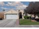Inviting home featuring a well-manicured lawn, mature tree, and a two-car garage at 7697 Morning Lake Dr, Las Vegas, NV 89131