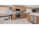 Well-lit kitchen with stainless steel appliances, light wood cabinets, and tiled countertops at 7697 Morning Lake Dr, Las Vegas, NV 89131