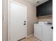 Practical laundry room with washer, dryer and dark upper cabinets for storage at 7697 Morning Lake Dr, Las Vegas, NV 89131