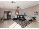 Bright living room with a ceiling fan, tile flooring, and access to the backyard at 7697 Morning Lake Dr, Las Vegas, NV 89131