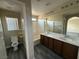 Bathroom with double sink vanity, framed mirror, shower-tub combination, toilet and wood look floors at 7929 Valladolid Ave, Las Vegas, NV 89178