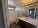 Bright bathroom featuring a tub-shower combo, a dark vanity, and a framed mirror at 7929 Valladolid Ave, Las Vegas, NV 89178