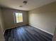 Neutral bedroom featuring sleek, dark laminate floors and a window providing natural light at 7929 Valladolid Ave, Las Vegas, NV 89178