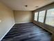 A bright bedroom features newly installed dark laminate flooring and sun-drenched windows at 7929 Valladolid Ave, Las Vegas, NV 89178