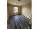 Cozy bedroom showcasing a newly installed dark laminate flooring and a well-lit window at 7929 Valladolid Ave, Las Vegas, NV 89178