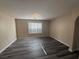 Inviting living room with wood-look floors, neutral paint and a large window offering natural light at 7929 Valladolid Ave, Las Vegas, NV 89178