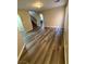 Living room with wood-look floors, neutral walls, and arched doorway leading to the staircase and kitchen at 7929 Valladolid Ave, Las Vegas, NV 89178