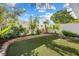 Private backyard features artificial grass, a low stacked stone retaining wall and mature landscaping at 7984 Laurena Ave, Las Vegas, NV 89147
