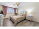 Bright bedroom featuring wood-look floors, ceiling fan, and natural light from the window at 7984 Laurena Ave, Las Vegas, NV 89147