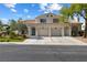 Traditional two-story home with a two-car garage, arched doorways, and fresh green landscaping at 7984 Laurena Ave, Las Vegas, NV 89147