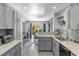 Open kitchen view with gray cabinets, granite countertops, and a view into the dining area at 7984 Laurena Ave, Las Vegas, NV 89147